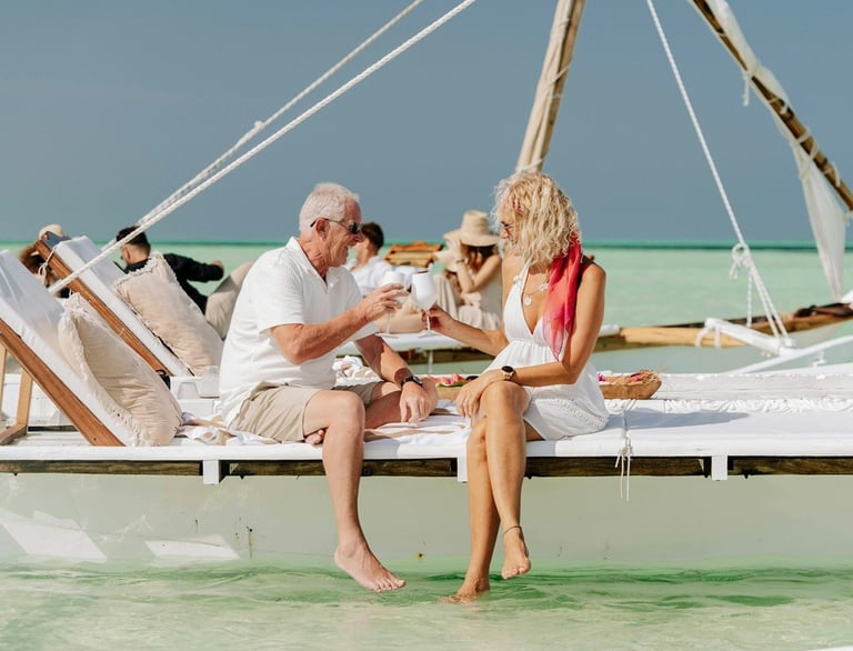 Un homme et une femme assis sur un voilier au bord de la plage avec de la famille et des amis