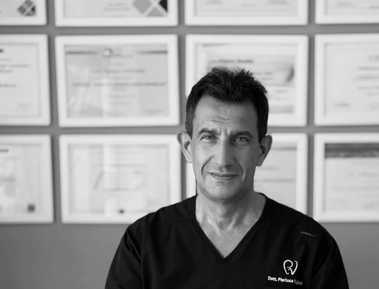 Ritratto del dentista professionista Dott. Pierluca Vivaldini in camice diplomi medici incorniciat