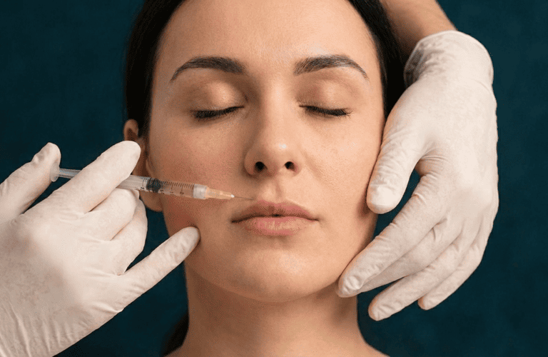 Una mujer recibiendo inyecciones de relleno labial por un profesional médico que usa guantes