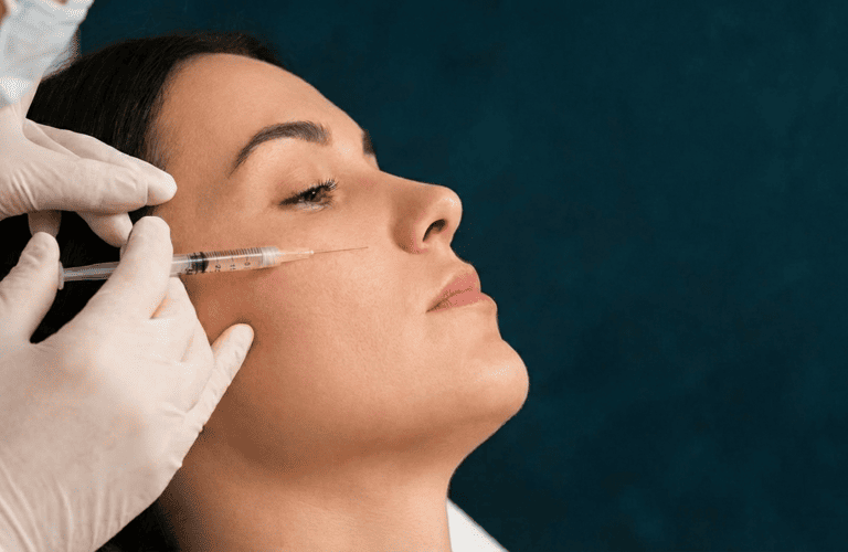 Una mujer recibiendo inyección de bioestimuladores en el rostro 