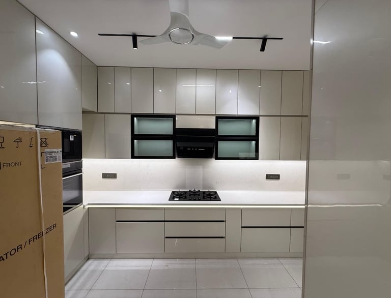 Modern modular kitchen with glossy beige cabinets, white quartz countertop, and integrated gas stove.