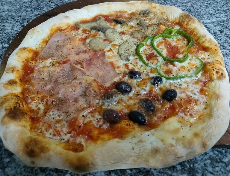 Pizza italiana farcita con prosciutto, funghi e olive, cotta nel forno del ristorante Big Game Maio.