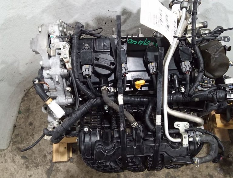 Used car parts with intake manifold and wiring harness on a pallet.