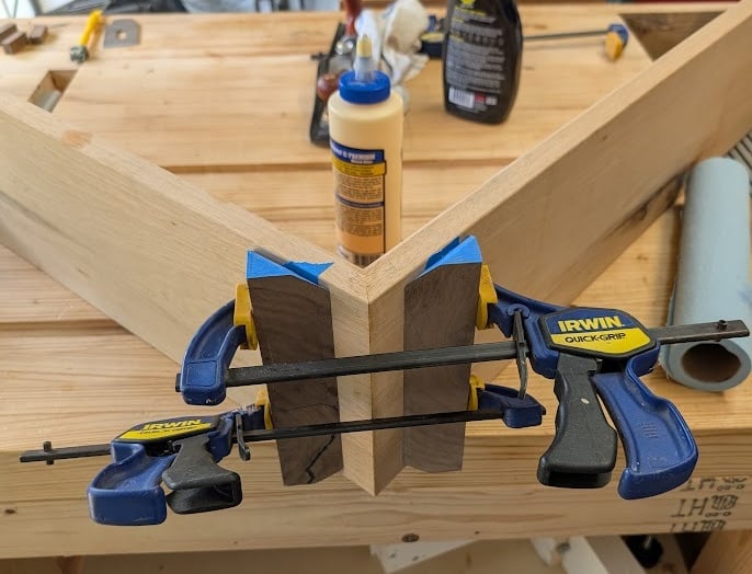 in progress waterfall table, clamped up in workshop  with woodglue and workbench in background