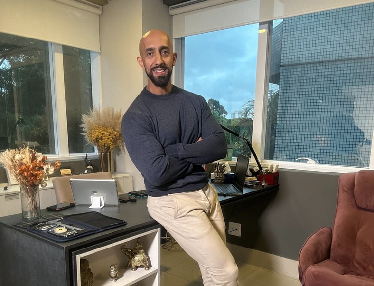 a man standing in a room with a desk and a chair