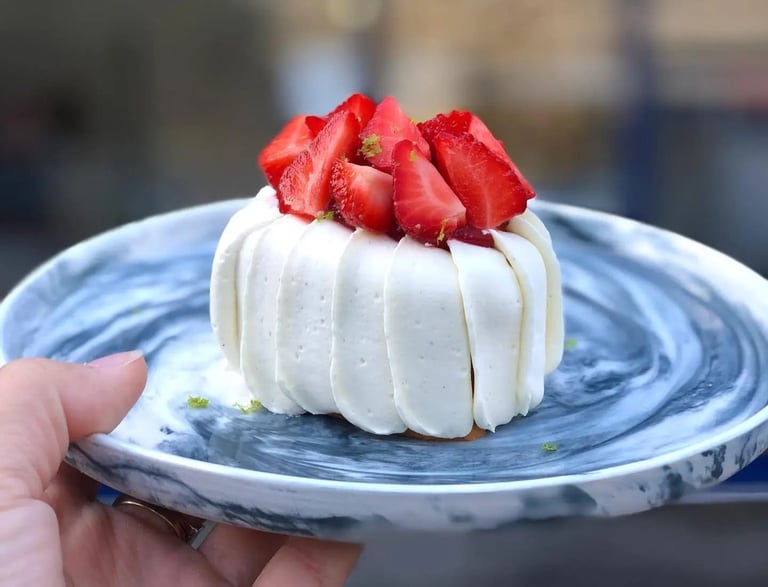 un délicieux fraisier dans une jolie assiette devant Robin Girard Pâtisserie