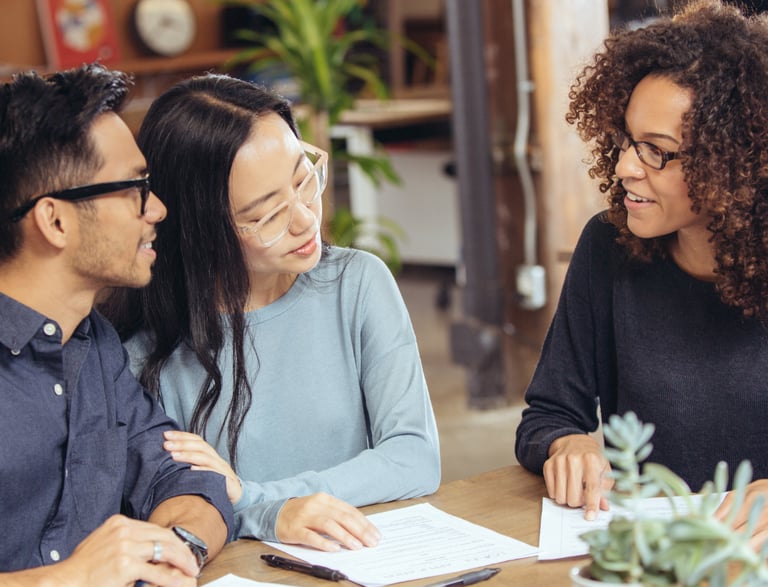 Home buyers signing a real estate offer with agent