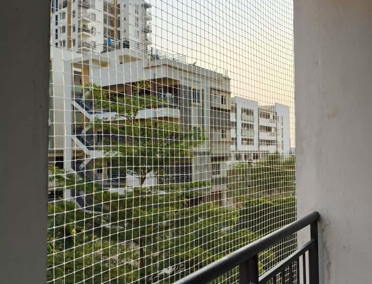 A close-up of a sturdy anti pigeon net installed on a window in Egmore.