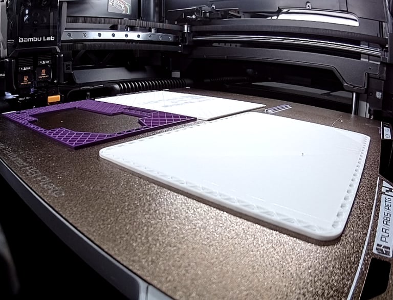 A Bambu Lab 3D printer creating purple and white plastic parts on a heated build plate.