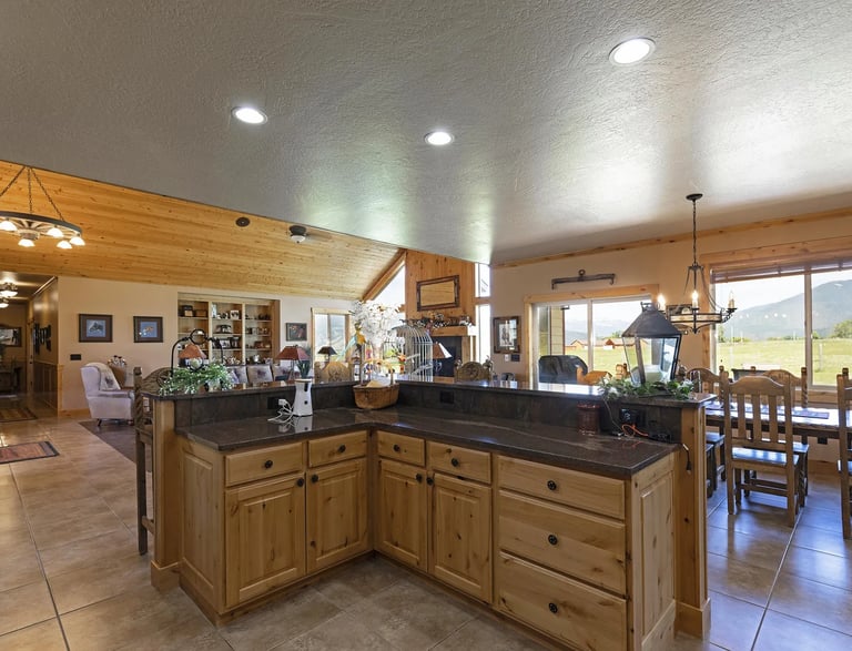 Victor MT custom house/home interior with kitchen island, wood cabinets, and granite countertop