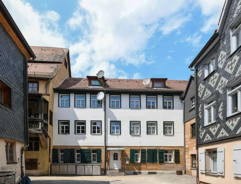 Historischer Innenhof mit gepflegtem Mehrfamilienhaus in der Fürther Altstadt – traditionelle Fassaden und ruhige Wohnlage.