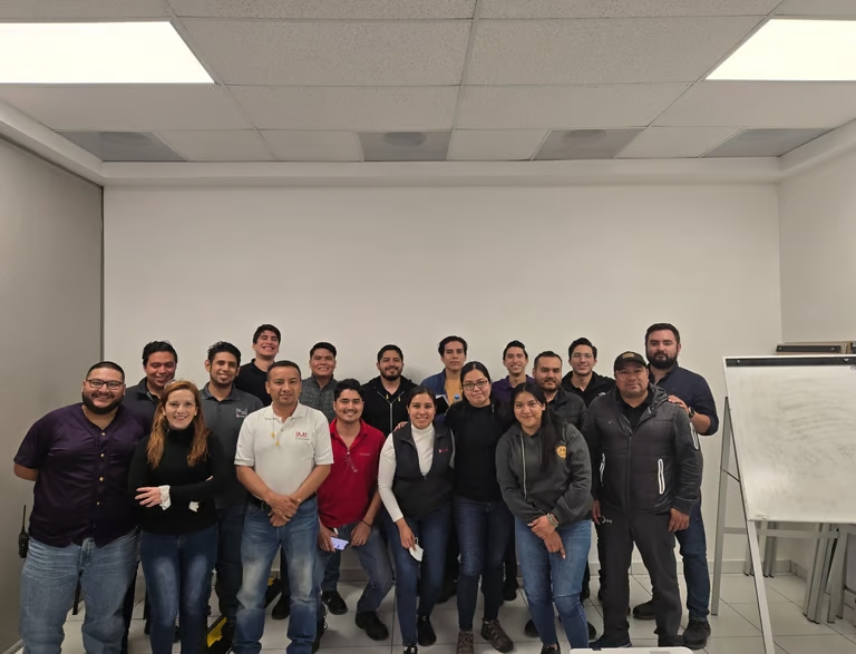 Fotografía grupal de un equipo de trabajo reunido en el aula tras concluir su capacitación empresar