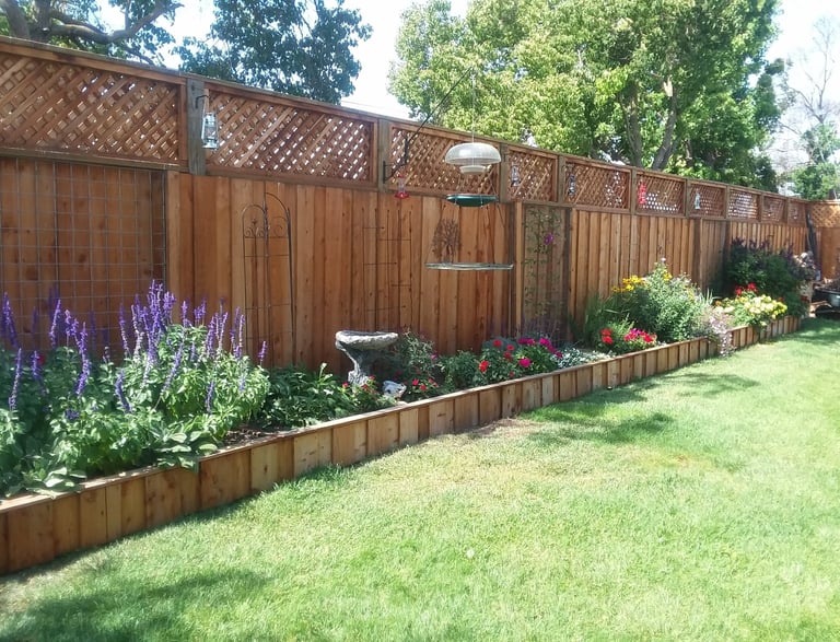 a new fenced in garden with a bird feeder