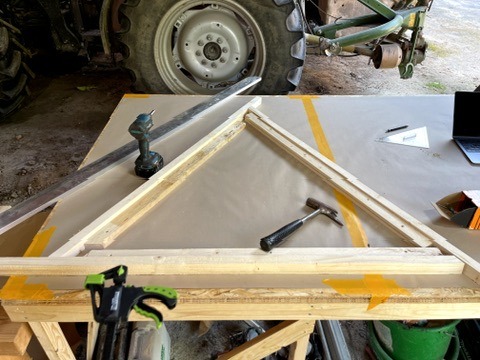 Ein Arbeitstisch mit Werkzeugen und einem Rahmen zum Bau von Dreiecken für einen Geodom