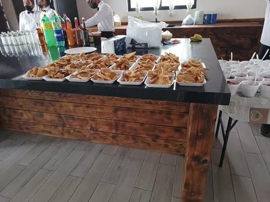 Barra de botanas con chicharrón preparado y bebidas en servicio de catering para evento en Querétaro.