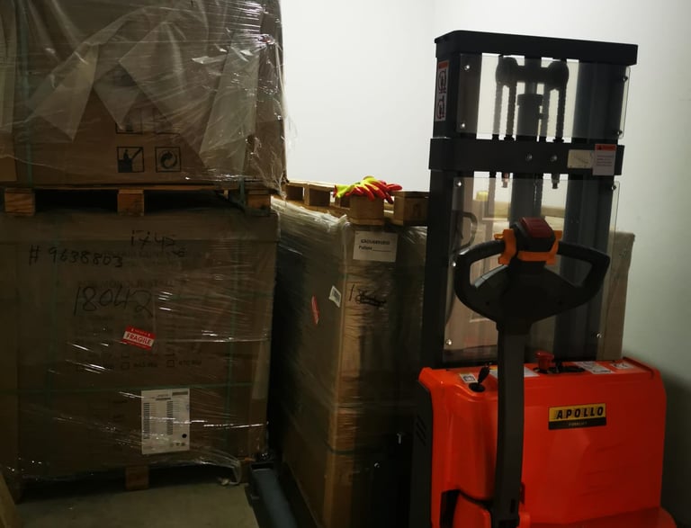Stacks of packaged boxes and a forklift in a warehouse, representing logistics and shipping.