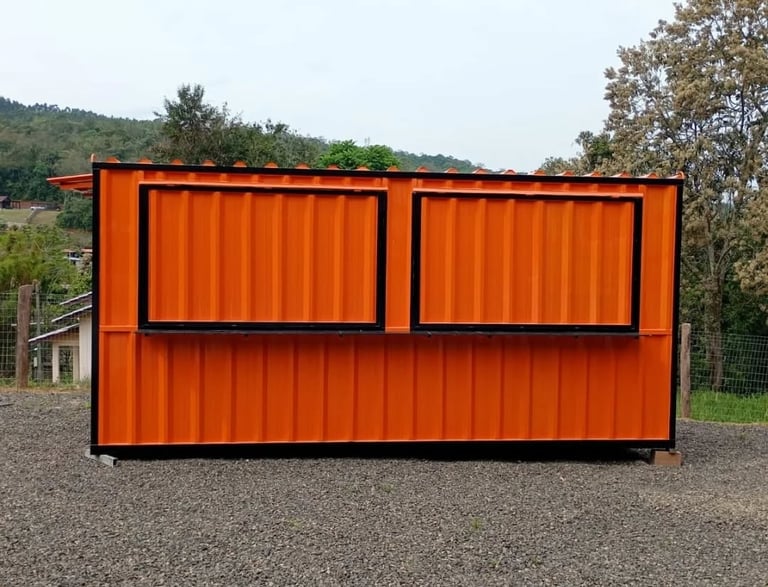 A portable orange shipping container kiosk with black window shutters used for a food stall or office.