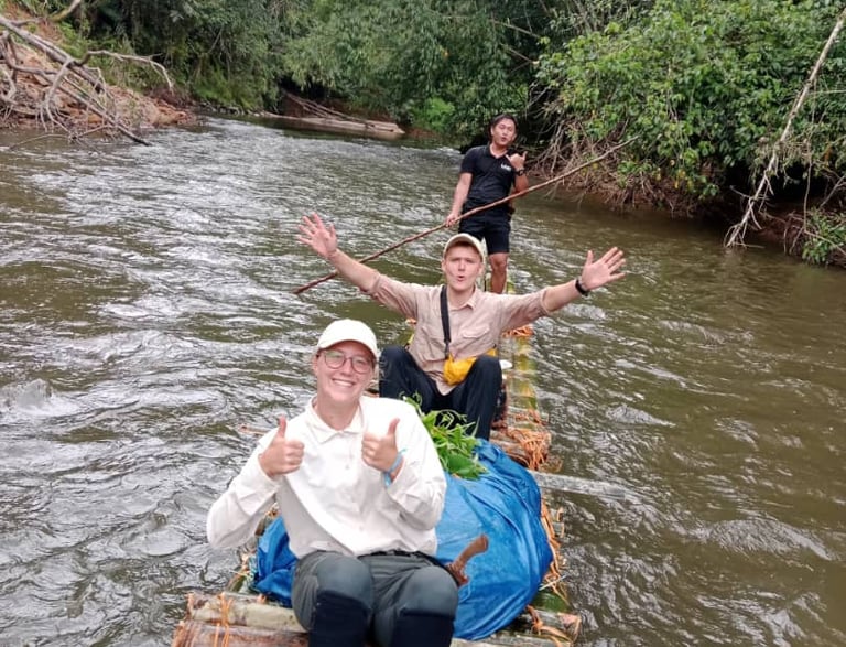 a man and woman sitting on a bamboo raft