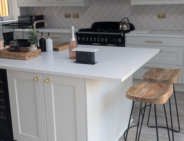 white image, with wooden stools, pink champagne on the countertop, with hidable popout outlets