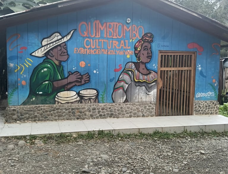 Mural of Afro-Colombian musicians on a blue wooden building for Quimbiombo Cultural heritage.