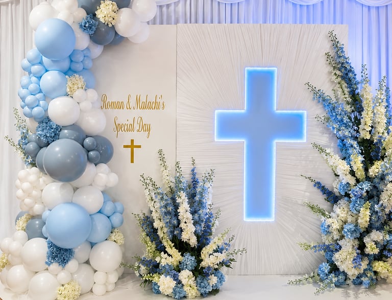 Elegant blue and white balloon arch with floral arrangements and a glowing cross for a baptism celebration.