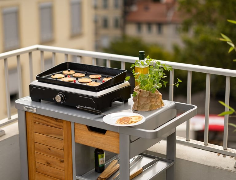 Plancha elettrica Campingaz utilizzata su un balcone cittadino.