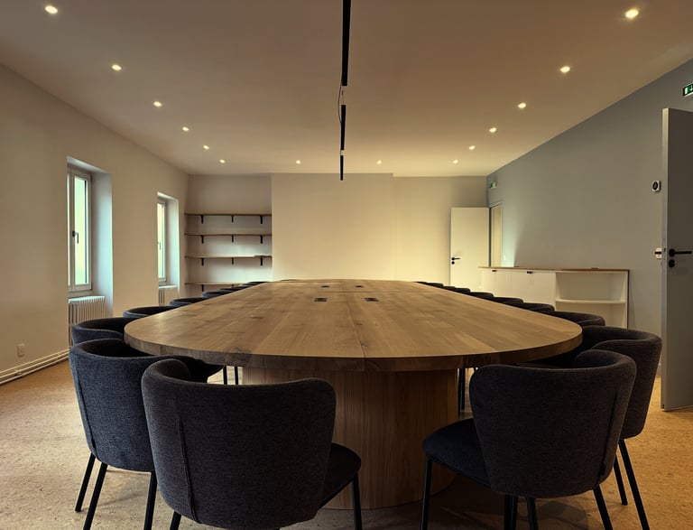 a large wooden table with chairs and chairs in a large office space