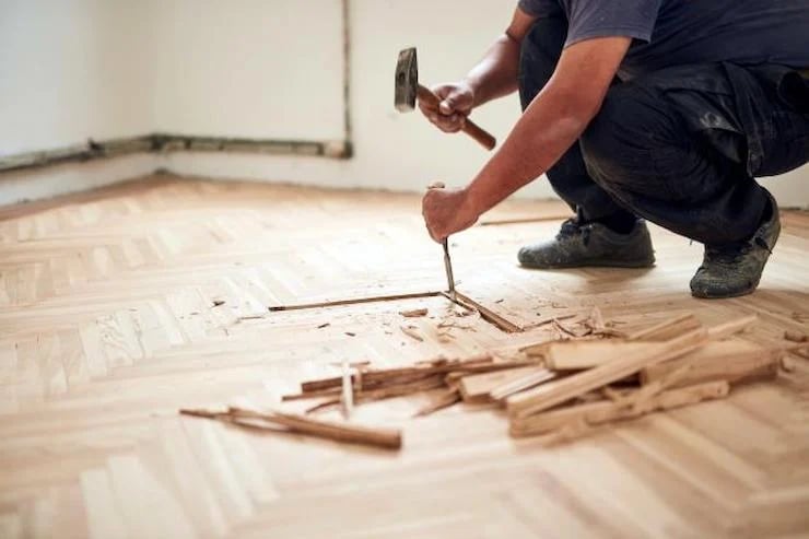 ouvrier qui casse le parquet au sol