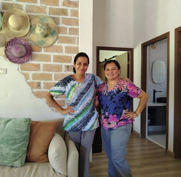 two women standing next to each other in a living room