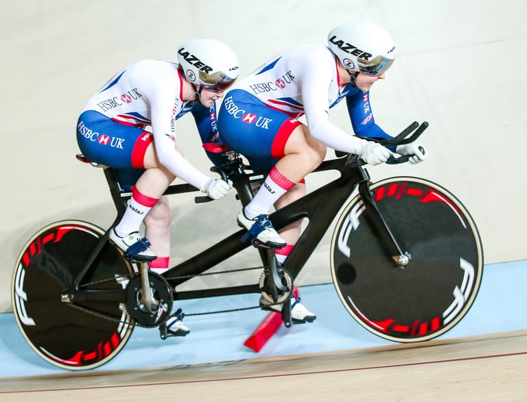 athletes racing a tandem on a velodrome