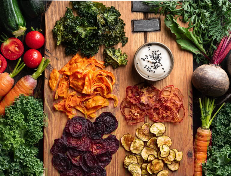 Tabla de madera con vegetales deshidratados como zanahoria, remolacha, tomates, berenjenas y otros