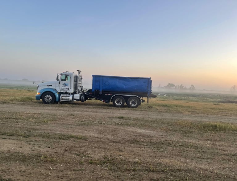 a truck with a blue dumpster on the side