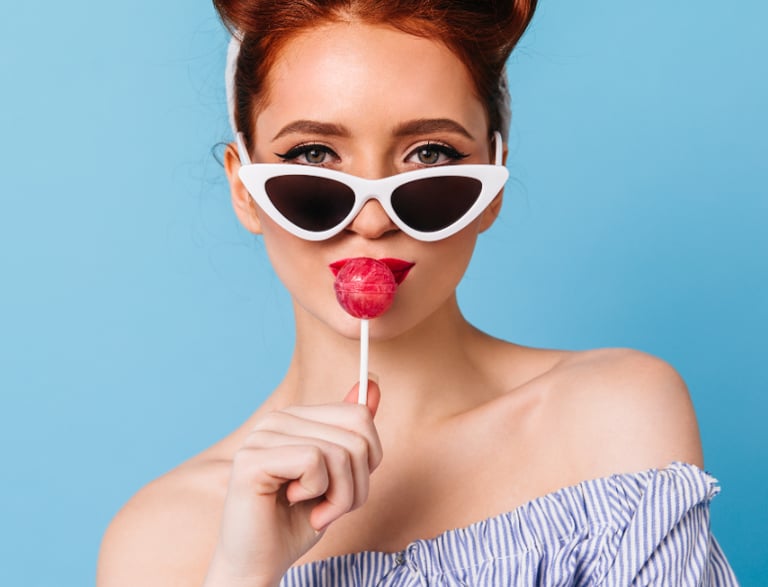 a woman with sunglasses and lollipops on a blue background
