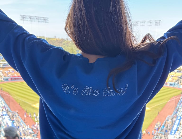 back of a sweatshirt on a girl at a baseball stadium