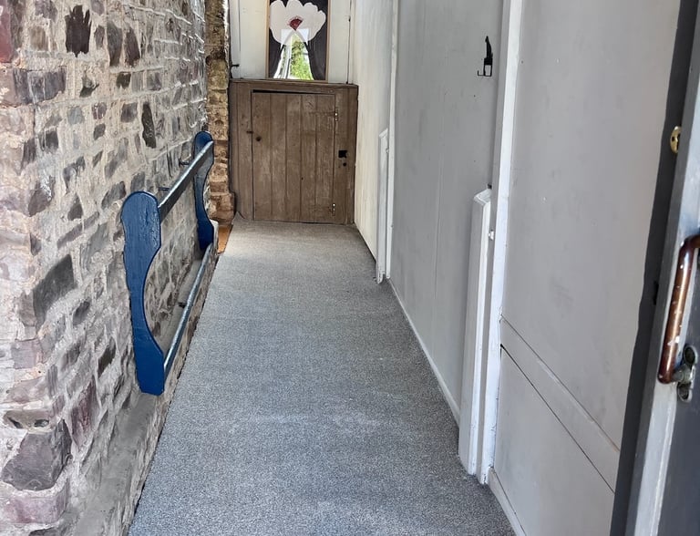 Completed stone hallway with new flooring and clean, finished walls.