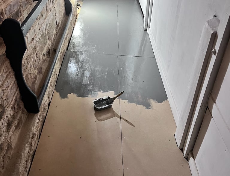 Bathroom floor mid-install showing plumbing and unfinished surfaces.
