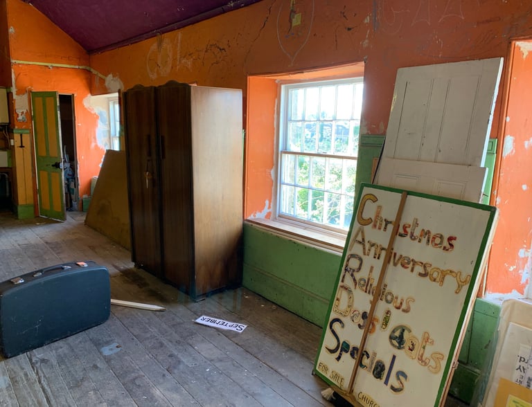 Transitional space showing partially stripped walls and renovation materials.
