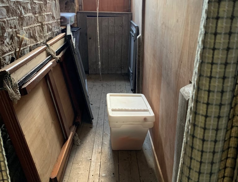 Narrow stone corridor with temporary fixtures during renovation