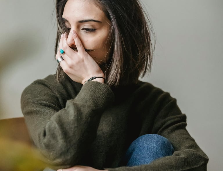 femme dont le visage et la posture indique une difficulté émotionnelle