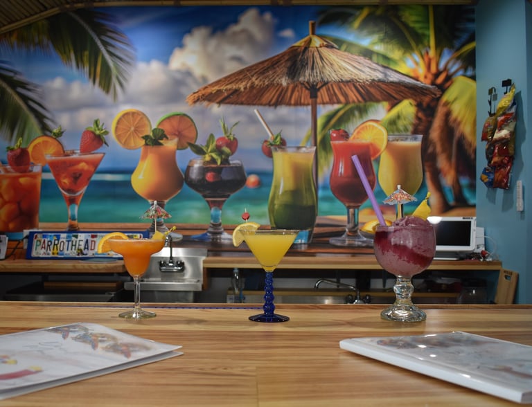 Tropical drinks on a bar with image of Tropical drinks behind it.