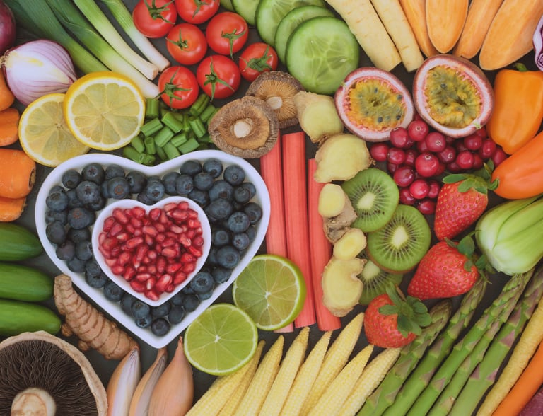 a heart shaped bowl of fruit and vegetables