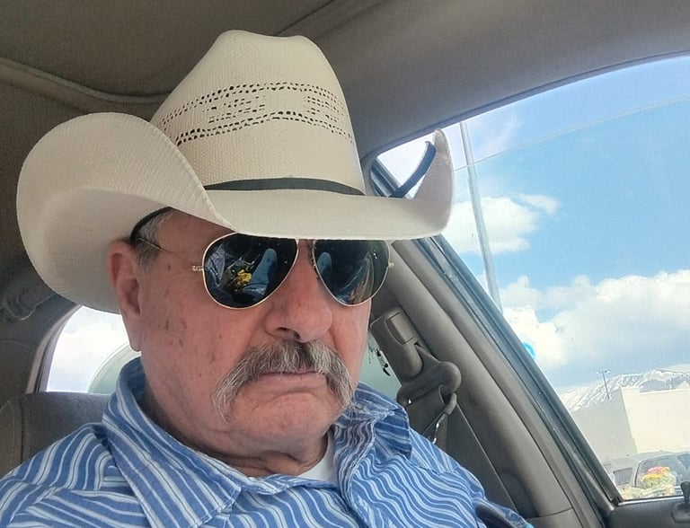 a man in a cowboy hat and sunglasses