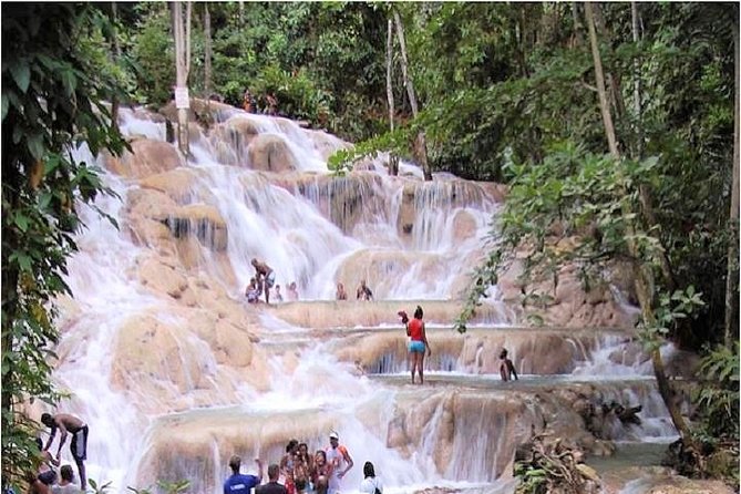 Dunn’s River Falls waterfall in Ocho Rios, Jamaica surrounded by lush tropical scenery