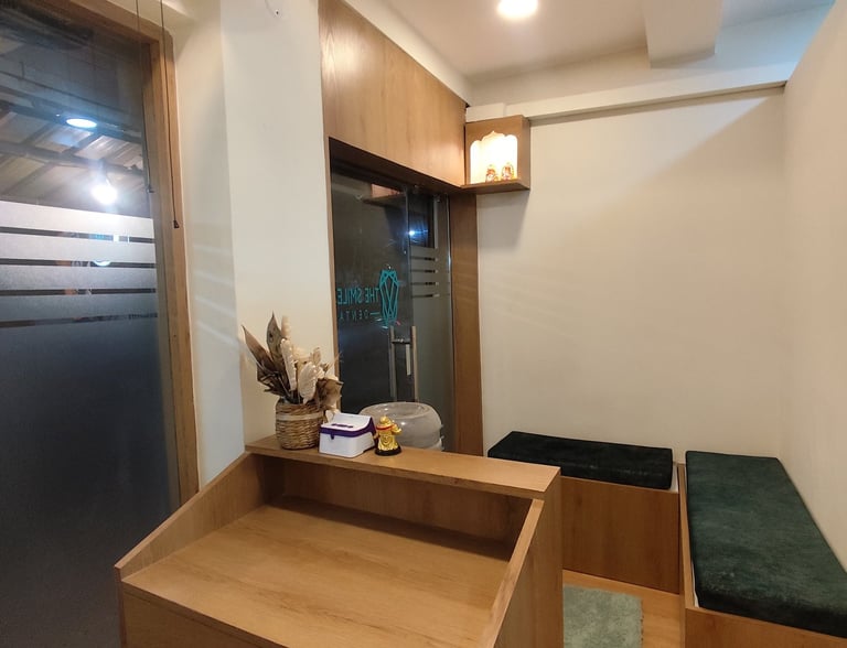 Modern dental clinic reception with wooden desk, waiting area benches, and minimalist interior design.
