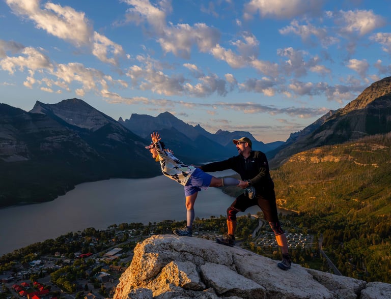 Couple posing playfully at sunrise on Bear’s Hump overlooking Upper Waterton Lake.