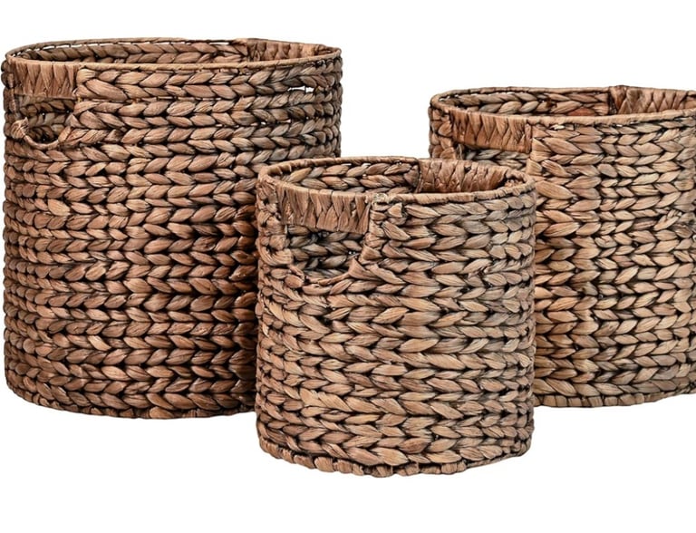 Set of three round woven seagrass storage baskets with handles for bathroom organization.