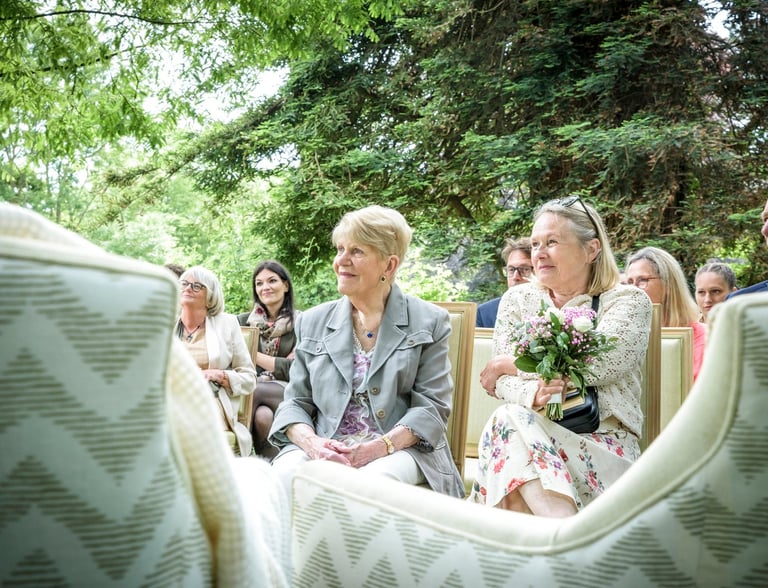 a bride and groomsmen are sitting in a chair