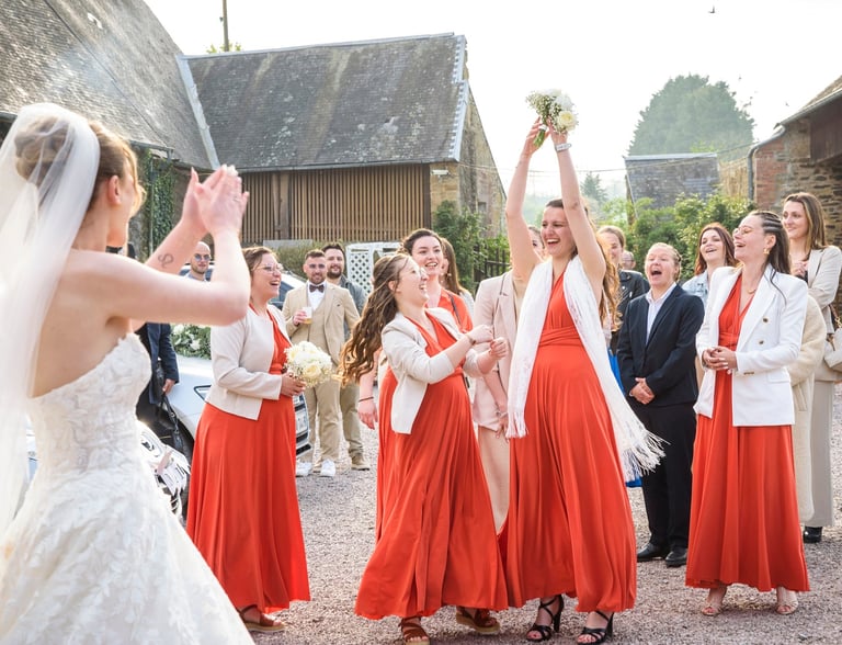 a bride and groomsmid are standing in front of a group of people