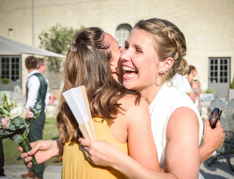 a woman in a yellow dress is hugging her friend