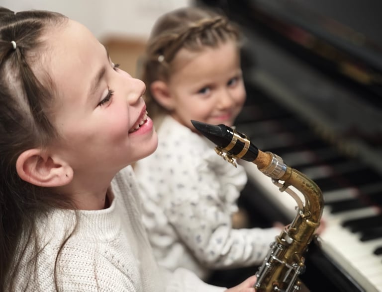 a girl playing a saxophone and saxophone with a little girl front piano
